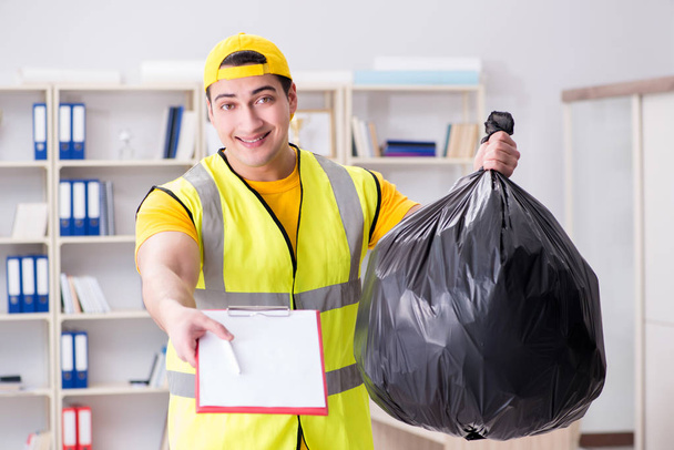 Hombre limpiando la oficina y sosteniendo la bolsa de basura - Foto, imagen