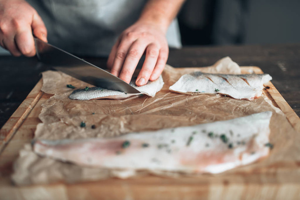 mannelijke chef-kok snijden van rauwe vis - Foto, afbeelding