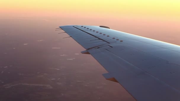 vliegtuig vleugel over landschap bij zonsondergang - Video