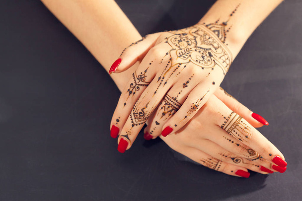 Red manicured hands with Mehndi  - Φωτογραφία, εικόνα