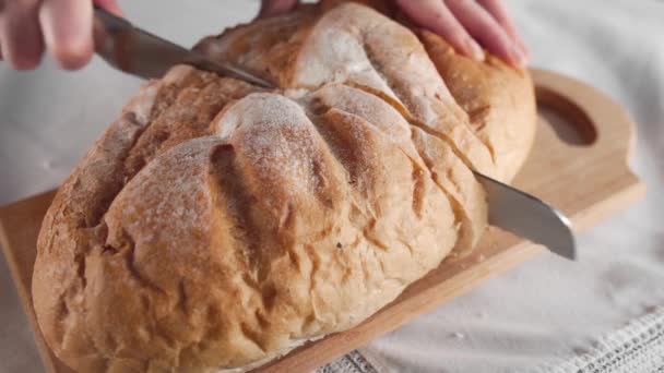 Домогосподарка нарізає хліб довгим ножем на дерев'яній дошці, сімейну вечерю, хліб, хлібобулочні вироби, свіжу пекарню
 - Кадри, відео