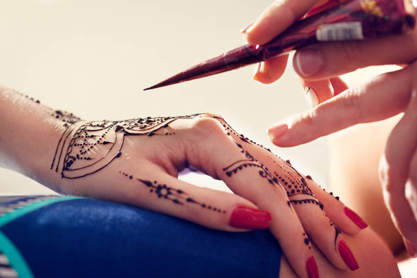 Red manicured hands with Mehndi  - Foto, Imagen