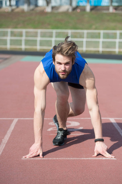 athletic bearded man with muscular body stretching on running track - Foto, Imagem