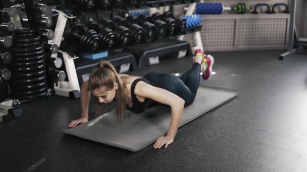 Νεαρή γυναίκα κάνει push ups σε ένα γυμναστήριο - Πλάνα, βίντεο