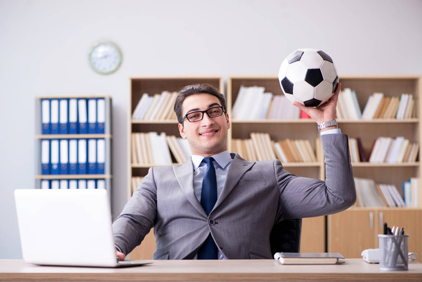 Επιχειρηματίας με μπάλα ποδοσφαίρου στο γραφείο - Φωτογραφία, εικόνα