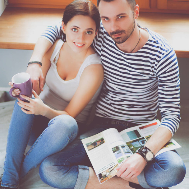 Couple moving in house sitting on the floor - Photo, image