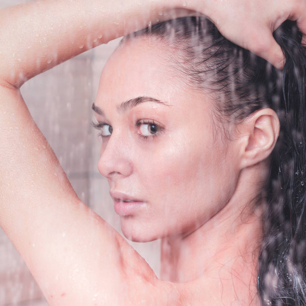 Jeune femme belle sous la douche dans la salle de bain
 - Photo, image