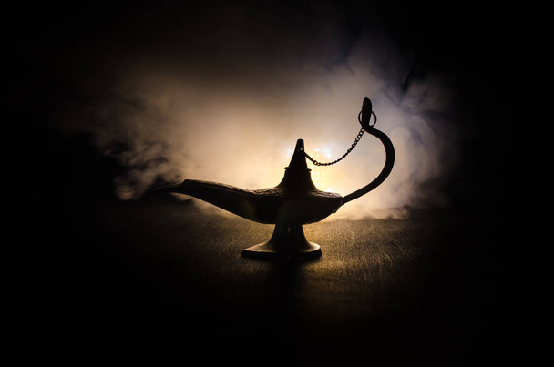 Antique arabian nights style oil lamp with soft light white smoke, Dark background. Lamp of wishes concept. Toned - Photo, Image