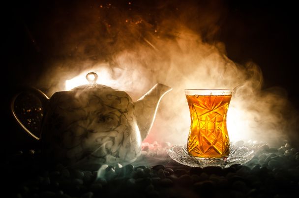 伝統的なガラスと照明、煙が黒の背景上の鍋でトルコ アゼルバイジャンのお茶。Armudu 伝統的なカップ - 写真・画像