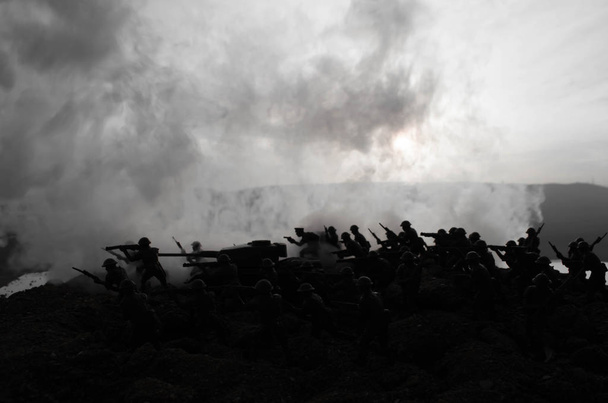 Concept van de oorlog. Militaire silhouetten vechten scène op oorlog mist hemel achtergrond, silhouetten van de Wereldoorlog soldaten onder bewolkte Skyline in de nacht. Aanval scène. Gepantserde voertuigen. Battle tanks - Foto, afbeelding