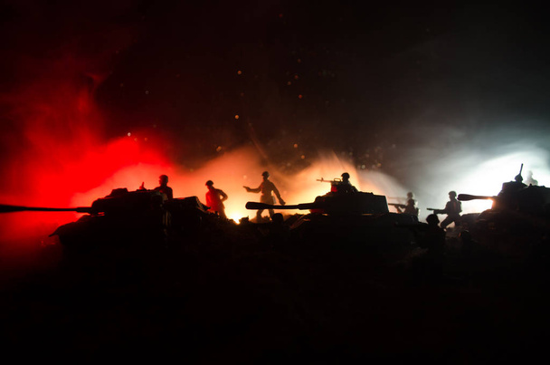 戦争の概念。戦争の霧空のシーンをかけて戦う軍のシルエットの背景、夜曇りスカイライン以下世界大戦兵士のシルエット。攻撃シーン。装甲車両. - 写真・画像