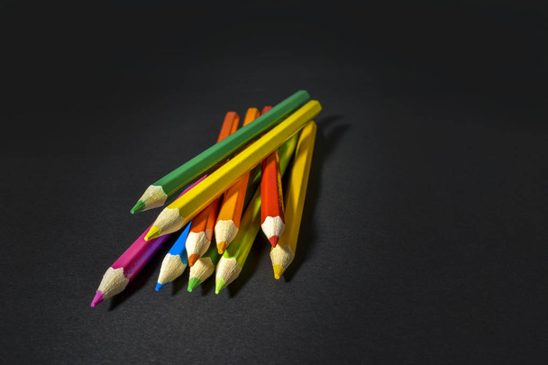 colored pencils on black background - Foto, imagen