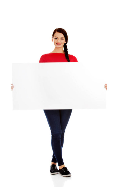 Beautiful young woman holding a blank banner - Фото, зображення
