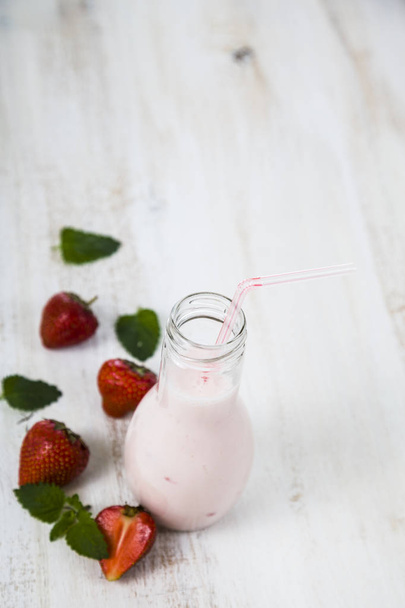 Smoothies and ripe strawberry on a wooden table.   - Φωτογραφία, εικόνα