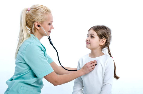 El pediatra escucha a la niña con la ayuda de un fonendoscopio
. - Foto, Imagen