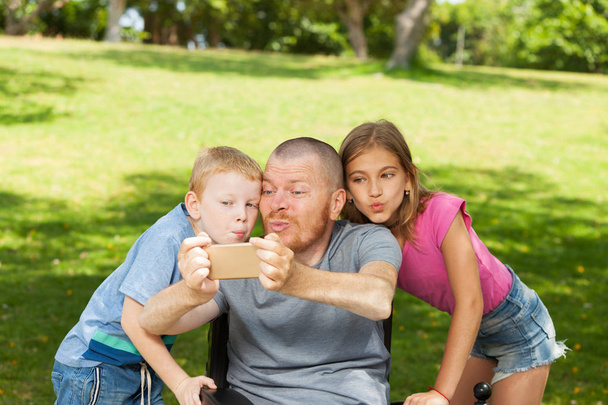 Disabled father playing with children. - 写真・画像