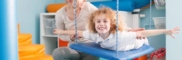 Criança em terapia swing
 - Foto, Imagem