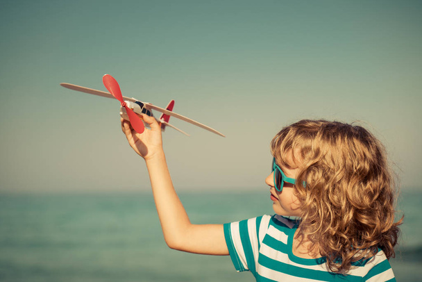 Enfant heureux jouant avec un avion jouet
 - Photo, image
