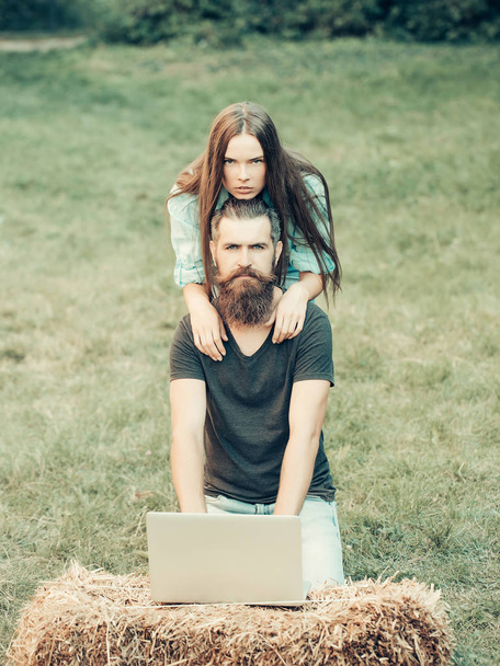 woman and brutal man using laptop on nature - Fotografie, Obrázek