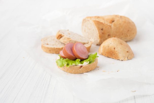 Sandwich with sausage on a white background. - Fotó, kép