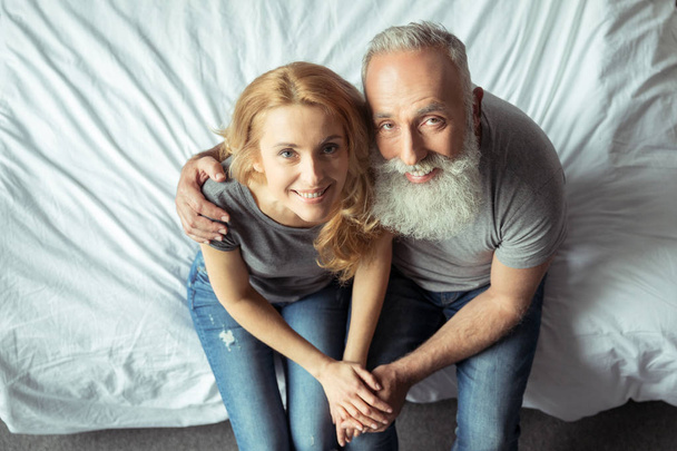 middle aged couple sitting on bed - 写真・画像