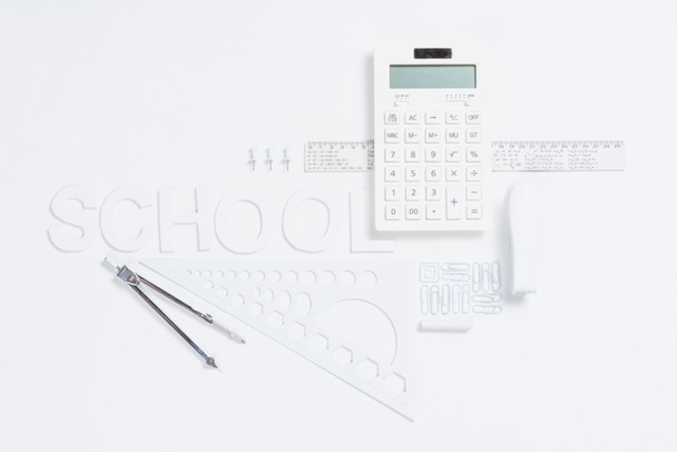 calculadora con reglas y grapadora con brújulas
 - Foto, imagen