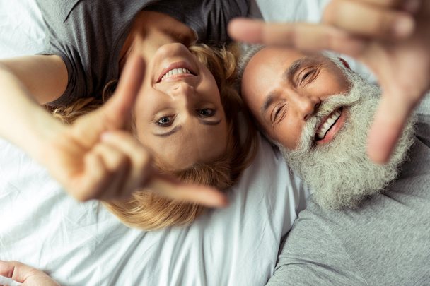 middle aged couple lying in bed - Photo, Image