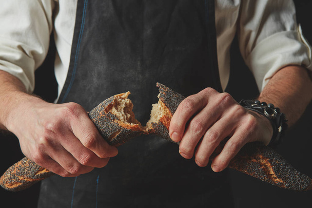 Male hands braking baguette - Zdjęcie, obraz