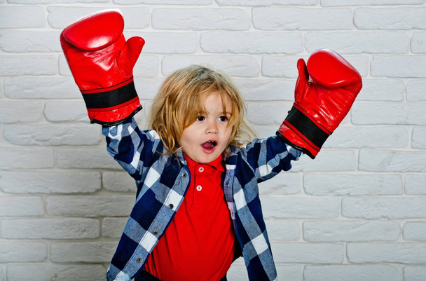 happy small boy in red boxing gloves, winning pose - Fotó, kép