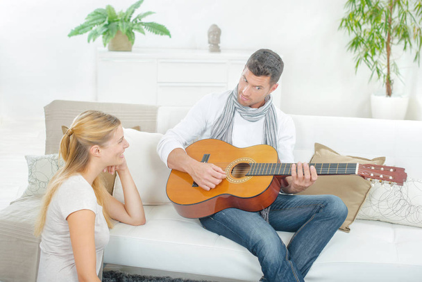 Man playing guitar to lady - Φωτογραφία, εικόνα