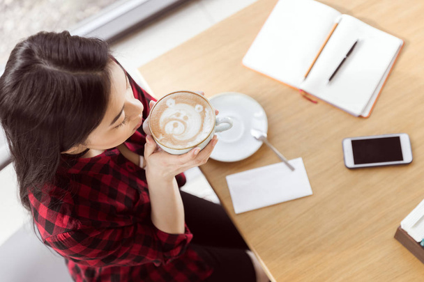 азіатська дівчина п'є каву
 - Фото, зображення