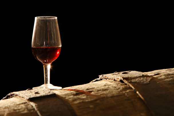 kieliszek wina stoi na beczki - Zdjęcie, obraz