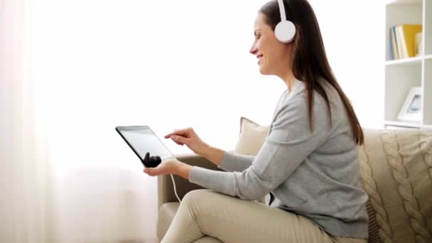 happy woman with tablet pc and headphones at home - Felvétel, videó