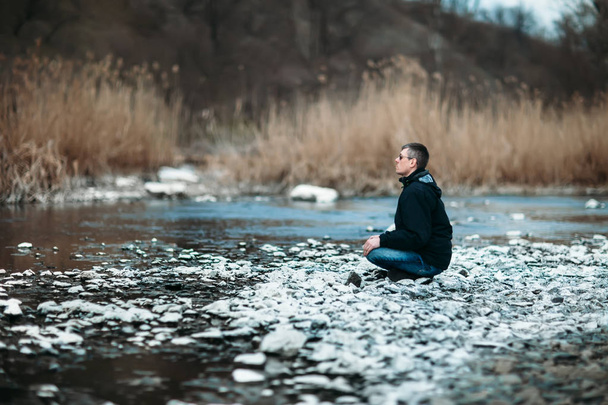 Homem meditando na bela paisagem fluvial
 - Foto, Imagem