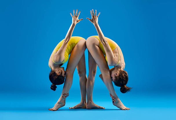 Two young women doing yoga asana  - Фото, изображение