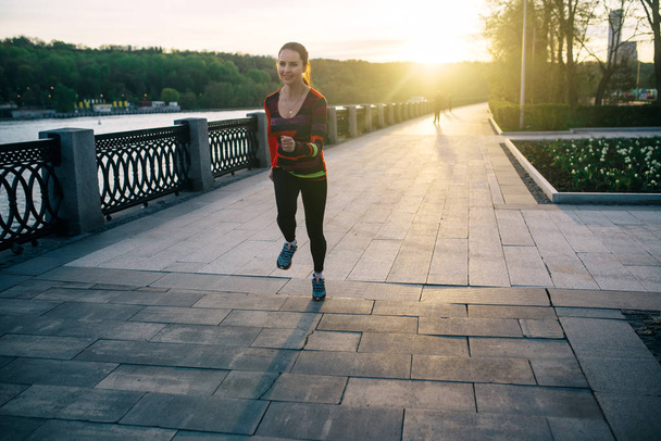 Girl running and training at sunset - Foto, afbeelding