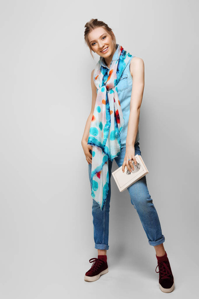 Pretty girl in rolled up jeans, gumshoes and colorful silk scarf - Foto, Imagen
