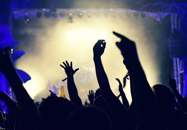 Толпа на музыкальном концерте, зрители поднимают руки
 - Фото, изображение