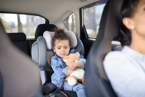 girl with teddy bear in car - Фото, изображение