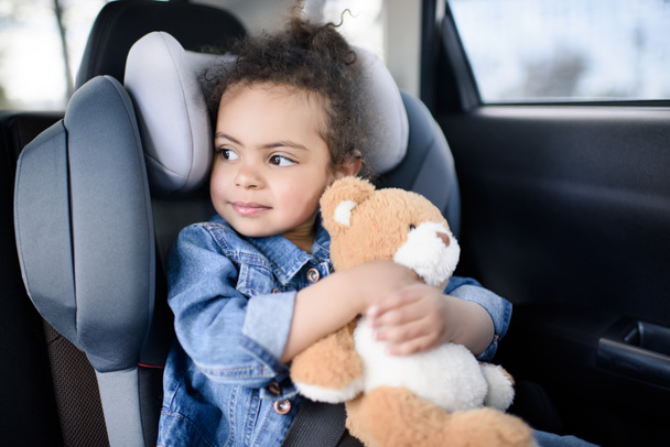 girl with teddy bear in car - Foto, Imagen