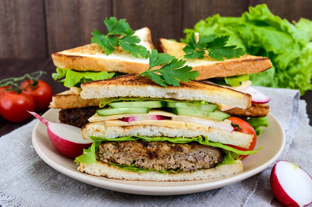 Sandwichs multicouches avec une escalope juteuse
 - Photo, image