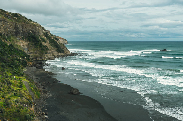 Plage volcanique avec sable noir et océan bleu
 - Photo, image