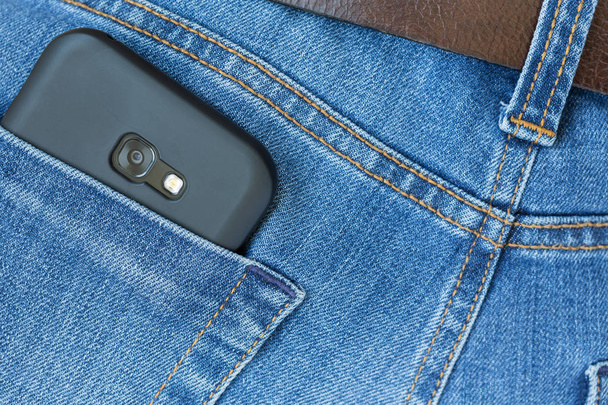 Mobile smart phone in jeans pocket.  - Valokuva, kuva