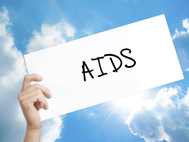 AIDS jel a fehér papíron. Az ember keze gazdaság papír szöveggel. Szigetelt - Fotó, kép