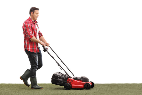 Gardener mowing a lawn with a lawnmower - Foto, afbeelding