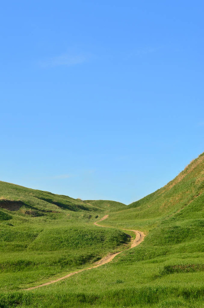 A letaposott út, átmenő egy csodálatos zöld hegyvidéki terep táj - Fotó, kép
