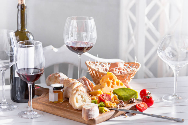 Wine, baguette and cheese on wooden background - Fotó, kép