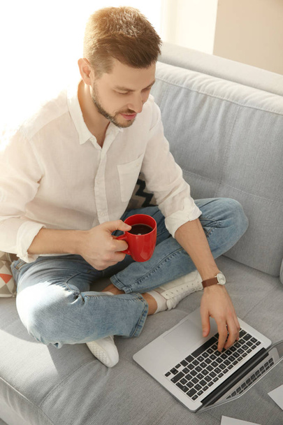 Handsome young man with laptop   - 写真・画像