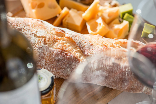 Wine, baguette and cheese on wooden background - Valokuva, kuva