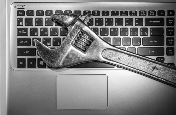 wrench  on black laptop keyboard  - Fotografie, Obrázek